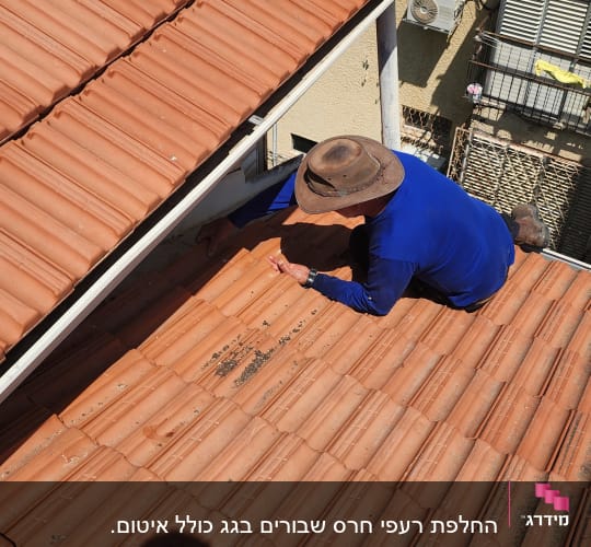 אדם עובד על גג רעפים עם כובע